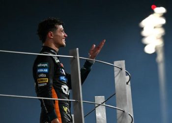 Pembalap McLaren’s, Lando Norris, merayakan gelar juara dunia F1 2025 di podium Grand Prix Abu Dhabi di Sirkuit Yas Marina, Abu Dhabi, Minggu (7/12/2025). (Andrej Isakovic/AFP)