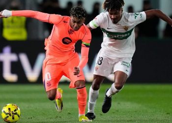 Pemain Barcelona Lamine Yamal (kiri) berebut bola dengan pemain Elche John Donald pada laga La Liga/Liga Spanyol antara Elche vs Barcelona (c) AP Photo/Jose Breton